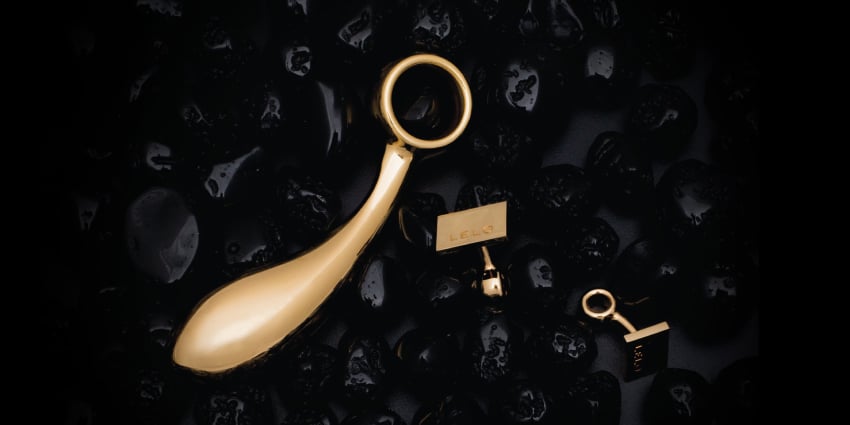 juguete erótico artesanal en oro sobre fondo oscuro, símbolo de lujo y exclusividad