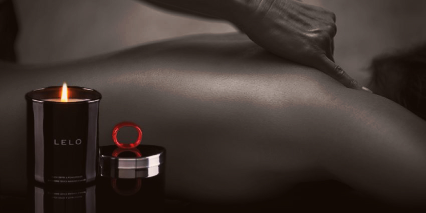 vela de masaje erótico LELO encendida junto a anillo vibrador durante un masaje sensual