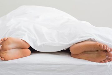 Pareja en la cama bajo una sábana blanca simbolizando la falta de deseo sexual o anafrodisia