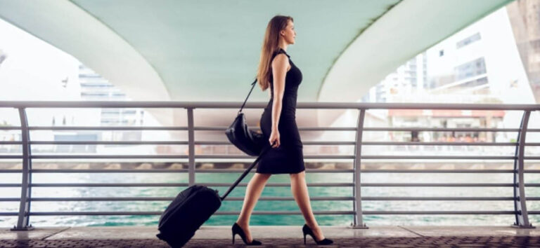 Mujer caminando con una maleta de cabina durante un viaje
