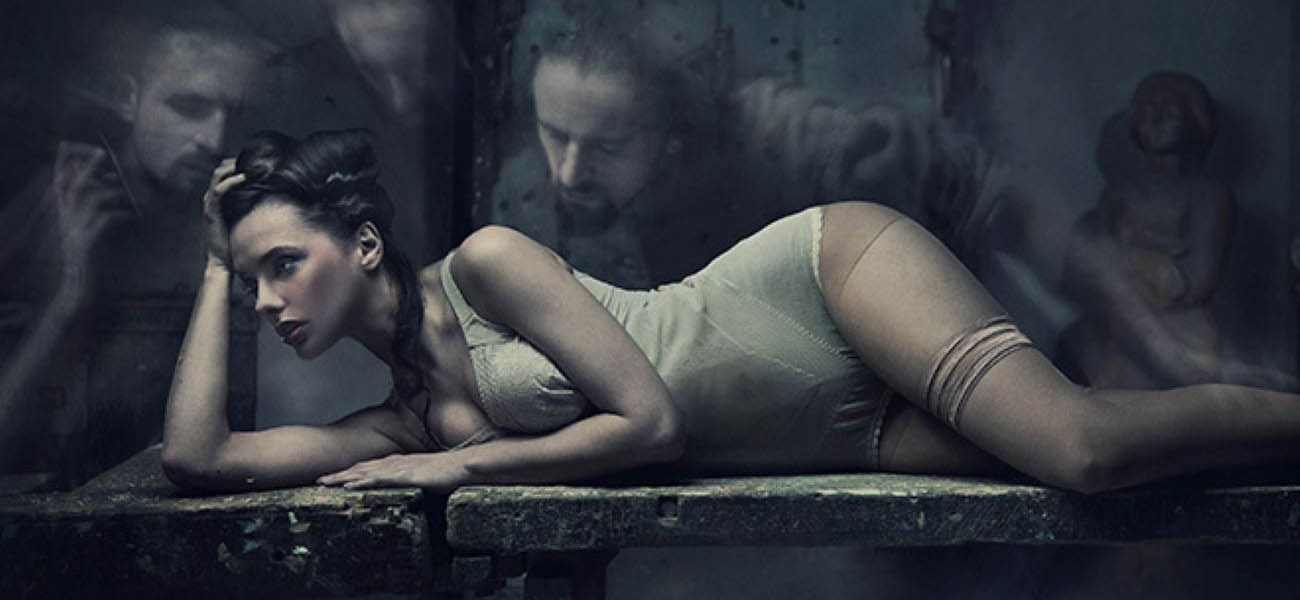 Mujer recostada en una escena oscura y sugerente utilizada para ilustrar prácticas consideradas de sexo extremo y fantasías sexuales.