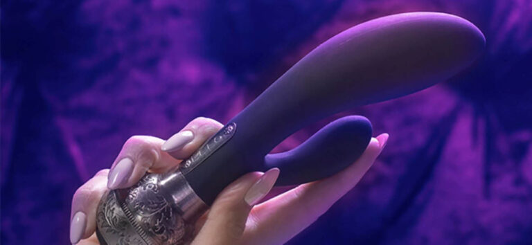 Vibrador de doble estimulación sobre fondo violeta inspirado en una sesión BDSM de estimulación anal