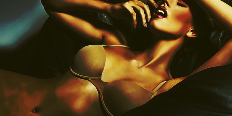 Mujer en ropa interior llevándose la mano a la boca en pose sensual