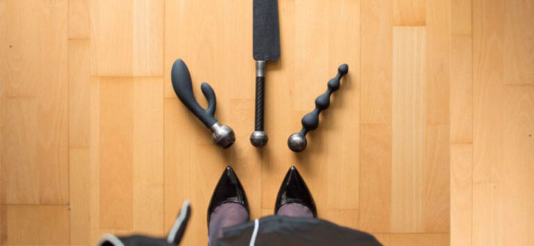 Bolas anales, un vibrador rabbit y un spanker preparados para una sesión de BDSM lésbico