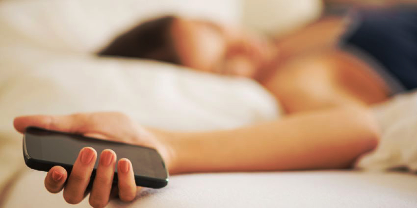 persona usando una app de citas en la cama para sexo casual