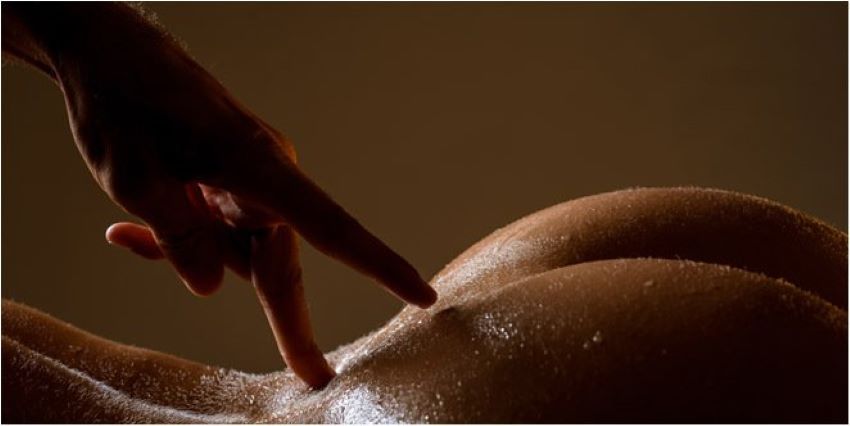 dedo recorriendo el hueco entre las nalgas de una mujer