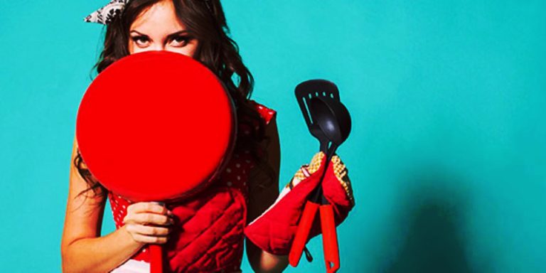 Mujer sosteniendo utensilios de cocina utilizados como objetos caseros para prácticas BDSM