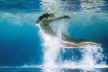 mujer sumergida en el agua en movimiento evocando libertad y sensación de caída