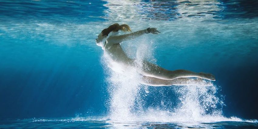 mujer sumergida en el agua en movimiento evocando libertad y sensación de caída
