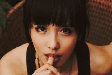 mujer mirando a cámara con gesto sugerente y dedo en los labios