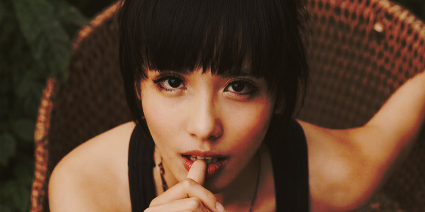 mujer mirando a cámara con gesto sugerente y dedo en los labios