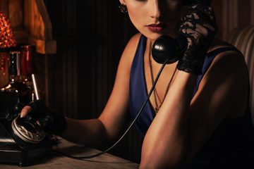Secretaria elegante hablando por teléfono en despacho con luz tenue