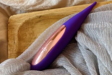 LELO DOT Travel, vibrador de clítoris compacto y discreto sobre una cama durante un viaje