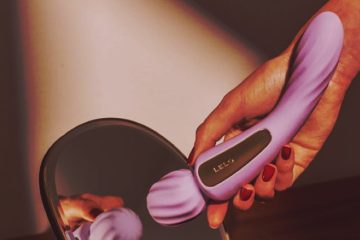 Mano sosteniendo LELO SWITCH lila frente a un espejo