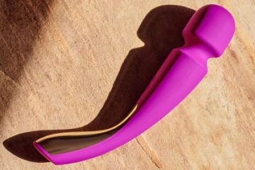 Vibrador wand recargable en color fucsia con diseño curvo y cabezal amplio