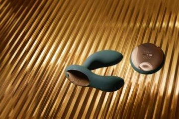 Juguete sexual de silicona y mando sobre fondo dorado, ejemplo de cuidado y limpieza