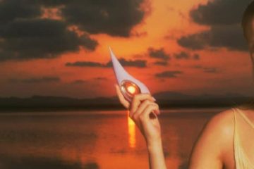 Mujer sosteniendo un juguete sexual en un entorno íntimo y evocador al atardecer