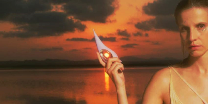 Mujer sosteniendo un juguete sexual en un entorno íntimo y evocador al atardecer