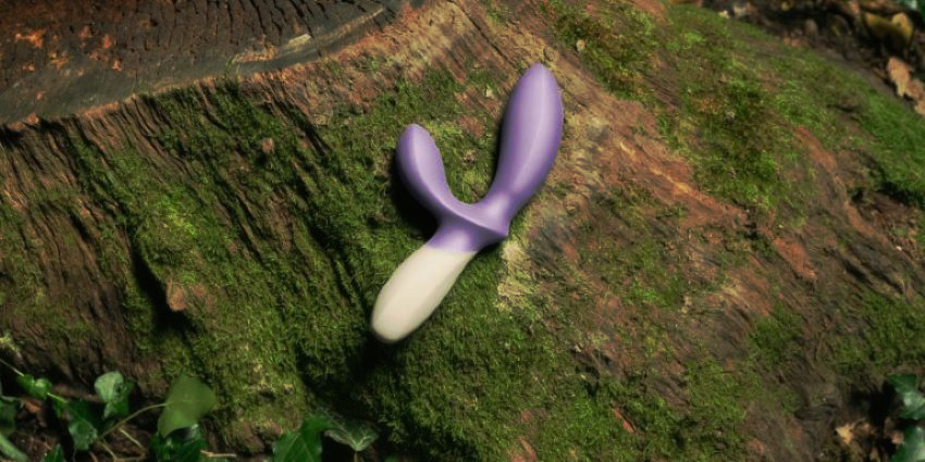 vibrador para estimulación del clítoris y punto g sobre un tronco en la naturaleza