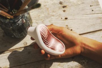 Mujer sosteniendo LELO SONA 3 succionador de clítoris con tecnología sónica en la mano