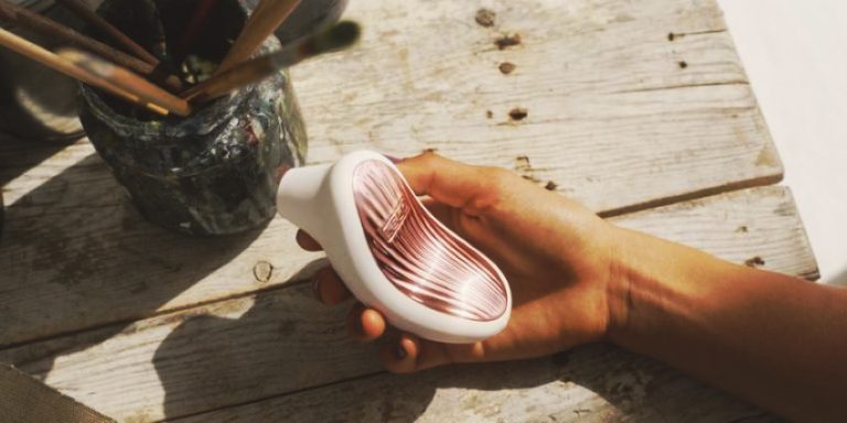 Mujer sosteniendo LELO SONA 3 succionador de clítoris con tecnología sónica en la mano