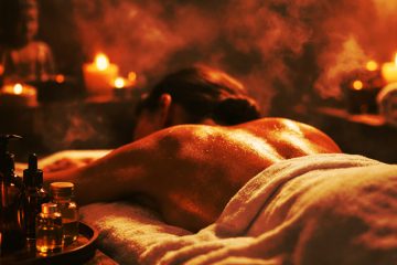 mujer recibiendo masaje relajante en spa con velas y aceite corporal