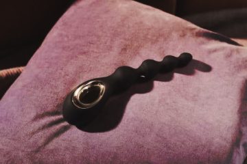 juguete anal para principiantes de silicona negra con diseño ergonómico sobre cojín