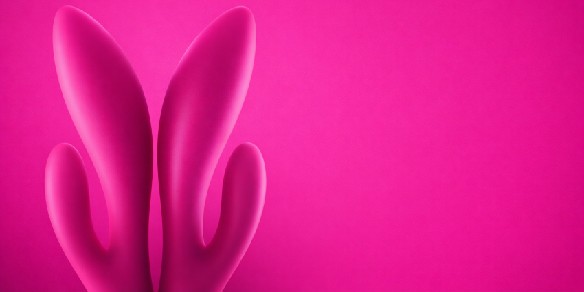 Vibrador rabbit en forma de conejito sobre fondo rosa representando la estimulación combinada del clítoris y el Punto G