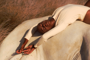 Mujer tumbada sobre una roca en postura relajada durante un momento de placer y conexión corporal
