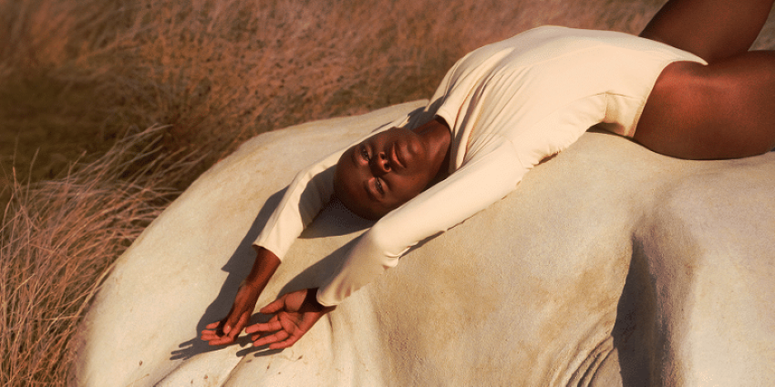 Mujer tumbada sobre una roca en postura relajada durante un momento de placer y conexión corporal