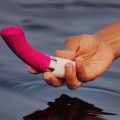 vibrador curvado en mano sobre agua representando forma y estimulación