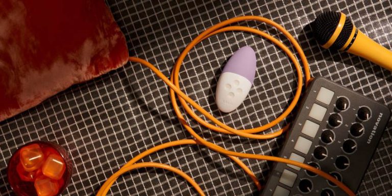 juguete erótico con control por app junto a dispositivos electrónicos y accesorios de sonido