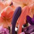 Juguetes sexuales inclusivos de LELO entre flores en tonos violeta y coral