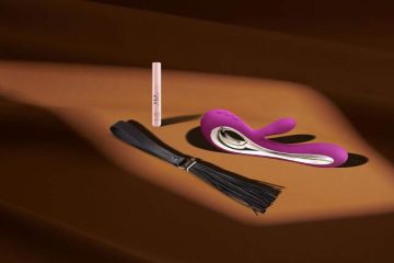 Juguetes sexuales y accesorios BDSM sobre una superficie iluminada