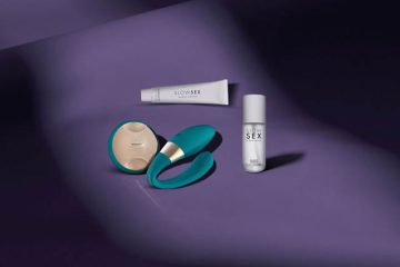 Bodegón de productos de bienestar sexual de la marca LELO y Slow Sex sobre un fondo púrpura suave, incluyendo un vibrador ergonómico de color turquesa, un estimulador circular y productos de cosmética íntima, diseñados para la comodidad y la accesibilidad.