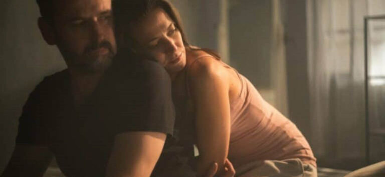 Pareja sentada en la cama atravesando una rutina sexual y una pérdida de intimidad
