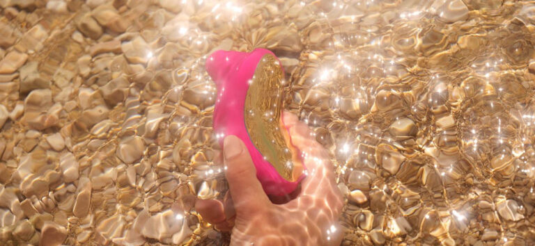 Juguete sexual sumergible siendo enjuagado con agua durante su limpieza