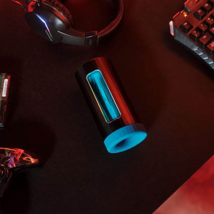 LELO F1S V3 sobre un escritorio junto a un teclado, unos auriculares y un mando de videojuegos