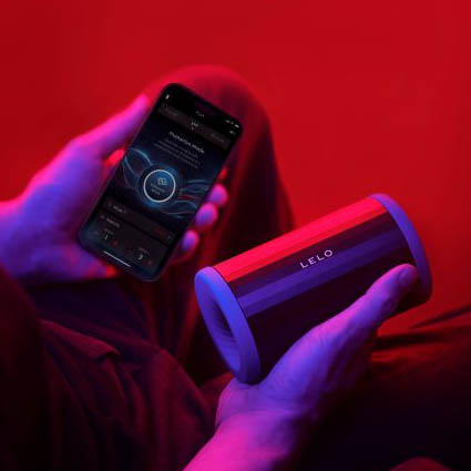 Hombre utilizando la aplicación de LELO junto al succionador masculino F2S Double Sonic.